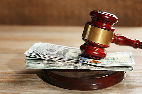 Law gavel with dollars on wooden table background, closeup